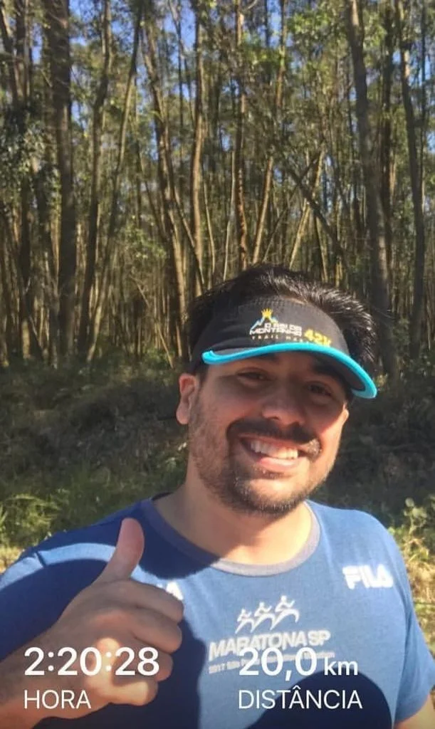 SkyTC founder Valtersky smiling during a marathon trail run with active physical distance tracker metrics on screen.